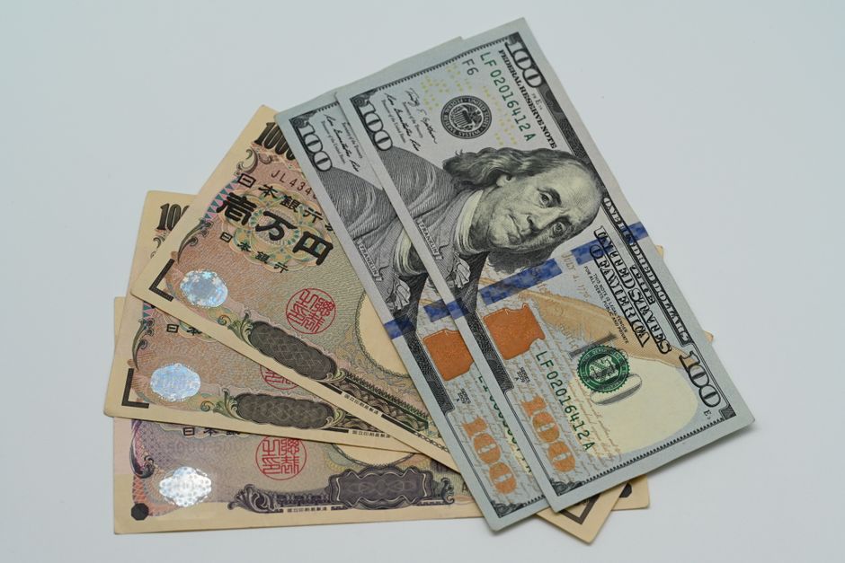 米ドル紙幣と日本円紙幣が並んで重なっているクローズアップ写真